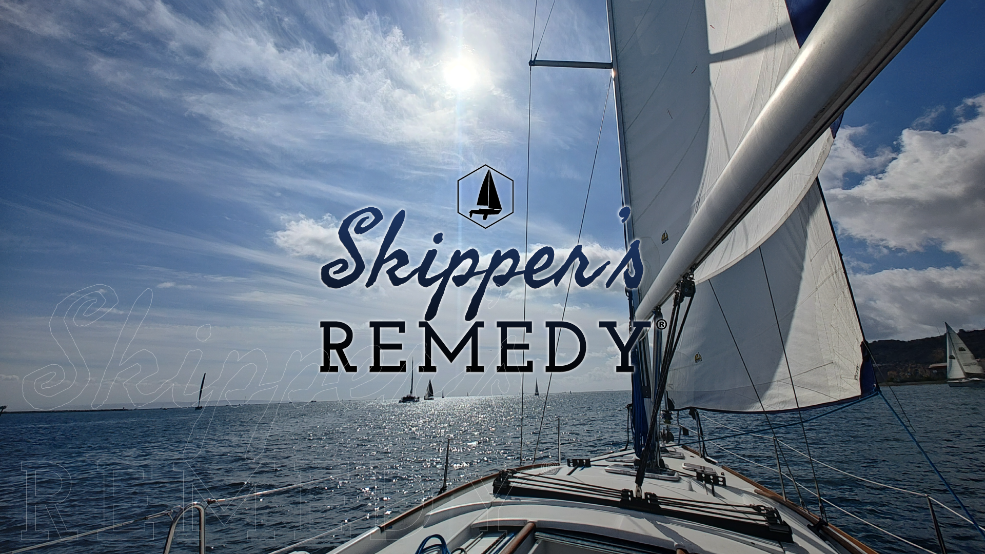 Sailboat with 'Skipper's Remedy' logo against a blue sky and ocean.