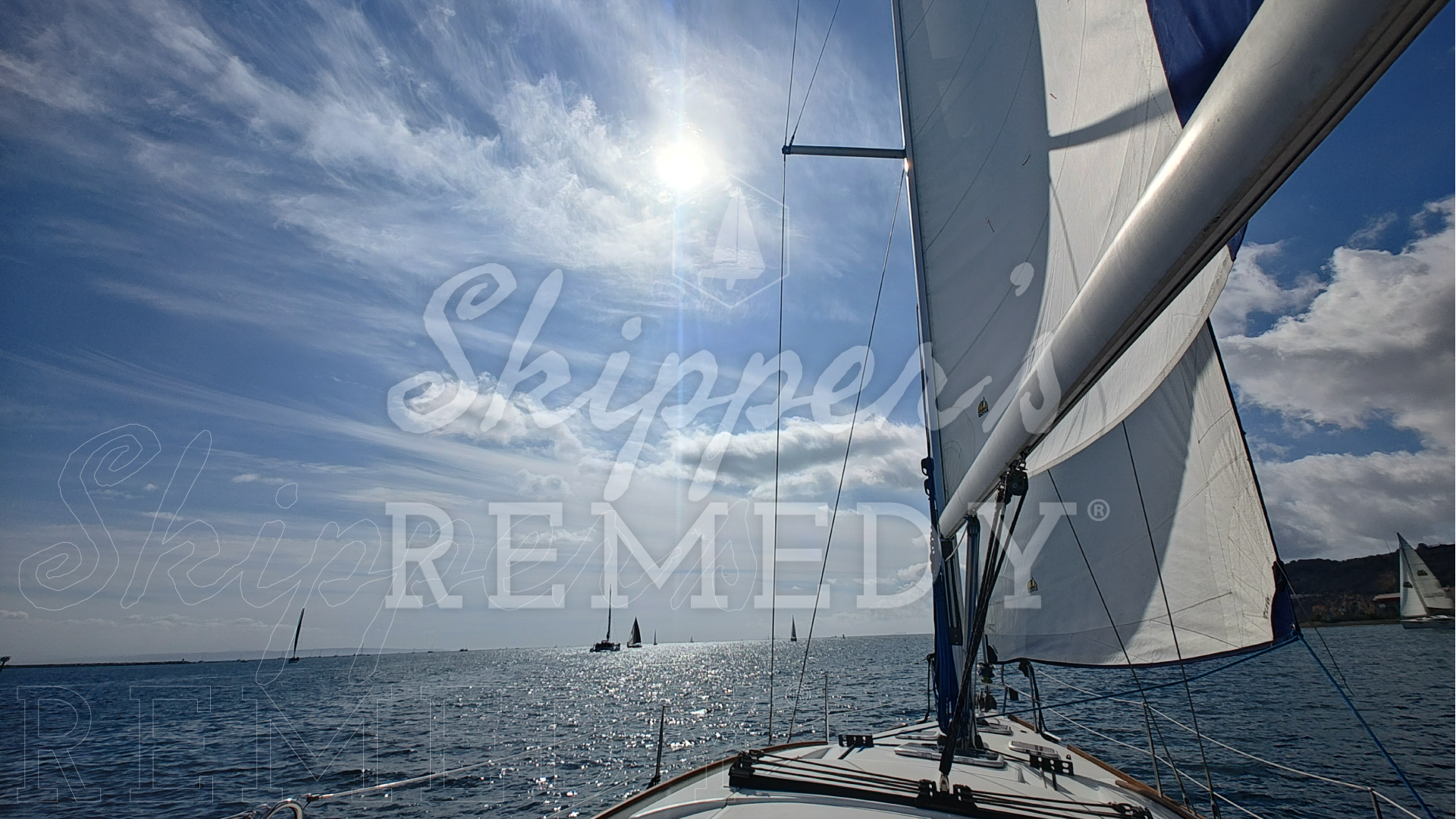 Sailing on a port tack, with a clear blue sky and sun; overlay with Skipper's Remedy logo