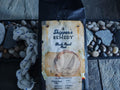 Skipper's Remedy Black Pearl Blend coffee, with a sailboat design on a stone surface.